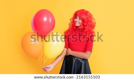 smiling teen girl with party balloon on yellow background