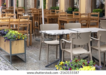 Empty table in outdoor cafe or restaurant. Tables and chairs at sidewalk cafe. Touristic setting, cafe table, sidewalk cafe furniture