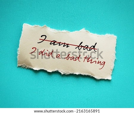 Torn stick note on red background with handwritten text I AM BAD changed to I DID A BAD THING, to overcome low self worth , take responsibility for mistakes, but not self degrade Royalty-Free Stock Photo #2163165891
