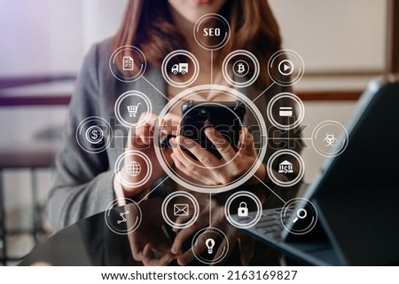 businesswoman or Designer using mobile phone with laptop and digital tablet laptop and document on desk in office with virtual icons network diagram in morning light

