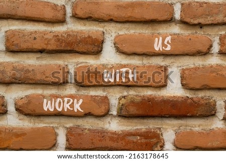 Work with us symbol. Concept words Work with us on red bricks on a beautiful brick wall background. Business, motivational and work with us concept. Copy space.