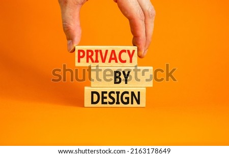 Privacy by design symbol. Concept words Privacy by design on wooden blocks on a beautiful orange table orange background. Businessman hand. Business finacial and privacy by design concept. Copy space.