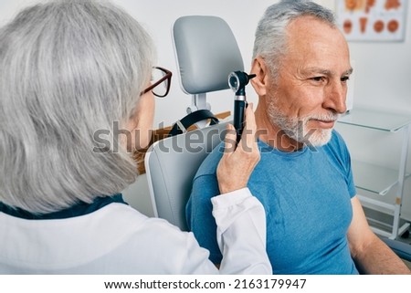 Senior man during ear test with audiologist at audiology. Diagnosis of impairment and hearing testing to senior people, otoscopy Royalty-Free Stock Photo #2163179947