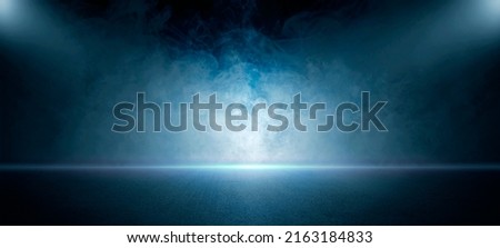 The dark stage shows, empty dark blue scene background, neon light, and spotlights The asphalt floor and studio room with smoke float up the interior texture for display products.