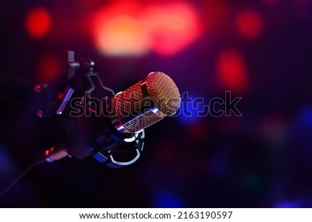 studio microphone in neon lights. sound recording equipment