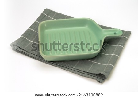 Empty ceramic tray with cloth isolated on white background. Mock up. Selective focus.