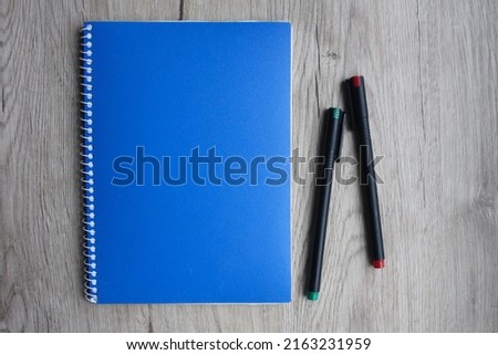 Business concept - Top view collection of blue notebook front, back pen, isolated on background for mockup. A grey notebook with pencil on a wooden table.