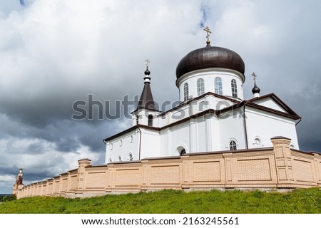 A white brick building is a church church church, a monastery stands behind a brick wall, an Orthodox shrine, a place for repentance, a prayer in the temple. High quality photo