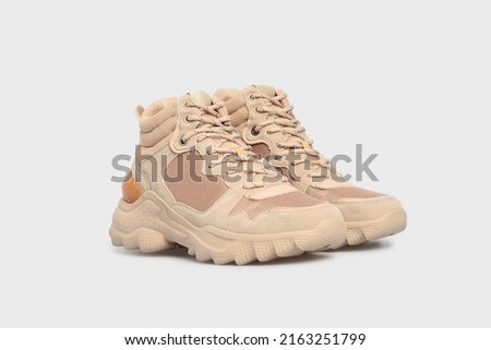 Beige sport high soled women's basketball shoes, sneakers, 
sports shoes, boots for female isolated on white background. Footwear, pair of running training shoes. Mock up, template Royalty-Free Stock Photo #2163251799