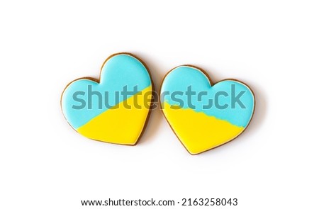 Two Heart shape ukrainian colours blue and yellow national flag gingerbread candies on white background.
