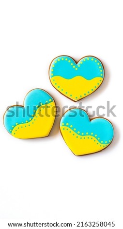 Three Heart shape ukrainian colours blue and yellow national flag gingerbread candies on white background.