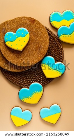 Heart shape ukrainian colours blue and yellow national flag gingerbread candies brown cork texture background. Vertical picture