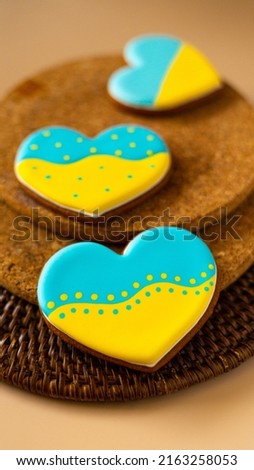Heart shape ukrainian colours blue and yellow national flag gingerbread candies brown cork texture background. Vertical picture