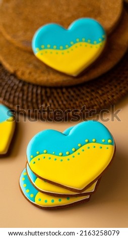 Heart shape ukrainian colours blue and yellow national flag gingerbread candies brown cork texture background. Vertical picture