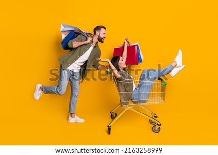 Full size profile side photo of young girl guy fast rush shopping center discount isolated over yellow color background Royalty-Free Stock Photo #2163258999