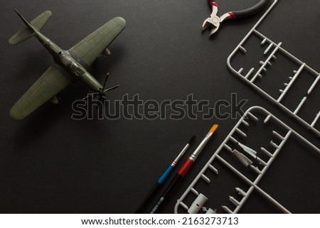 Scale model of a fighter aircraft with details and tools. Plastic assembly kit Royalty-Free Stock Photo #2163273713