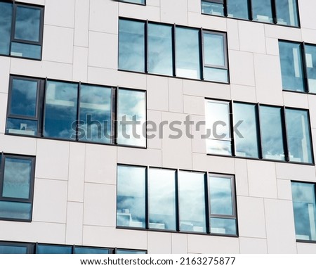 Amazing looking facade of a building in Tallinn. White facade with nice shiney reflecting windows. Modern architecture design. Sunny summer day
