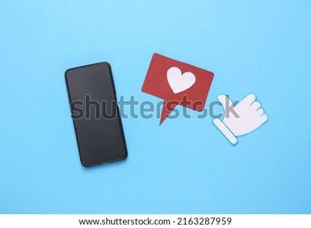 Smartphone with thumbs up and like notification icons on blue background. Travel concept. Rating, followers feedback. Top view