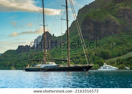 Long range expedition sailing super yacht at anchor in Cook's Bay, Moorea, French Polynesia, with beautiful volcanic mountains in the background, green tropical vegetation