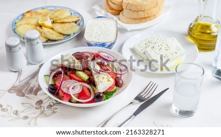 Greek food background. Ouzo, Greek salad, tzatziki, assortment of feta. Top view. Traditional Greek taverna menu. Close up Royalty-Free Stock Photo #2163328271