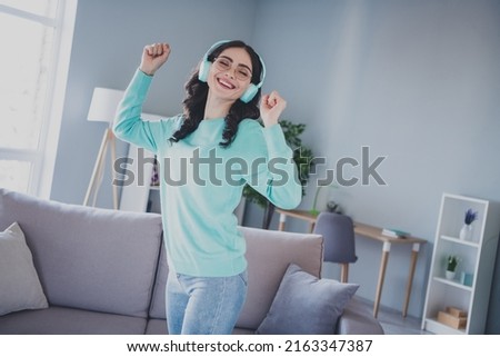Photo of young cheerful pretty woman have fun listen music headphones dance living-room free-time indoors