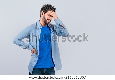 Worried young man holding his forehead, Worried man isolated, tired man holding his head, man with headache Royalty-Free Stock Photo #2163368307