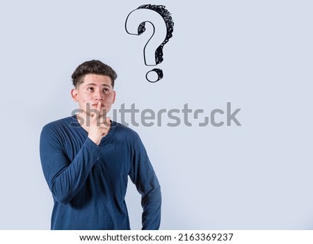 Thoughtful young man looking up with exclamation marks, Thoughtful man with exclamation marks on isolated background, Indecisive man looking up , Concept of man asking with exclamation marks
