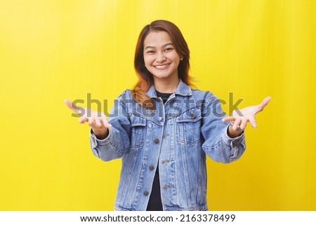 happy asian woman standing while showing something