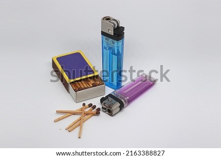 the set of lighters consists of two gas lighters and a wooden matchbox Royalty-Free Stock Photo #2163388827
