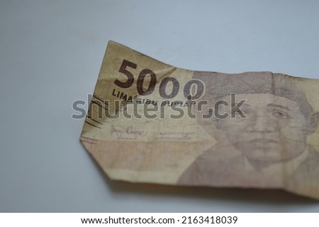 A five thousand rupiah denomination issued by Bank Indonesia which is used as a means of buying and selling transactions, Indonesian paper currency