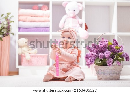 baby with lilac flowers at home or kindergarten