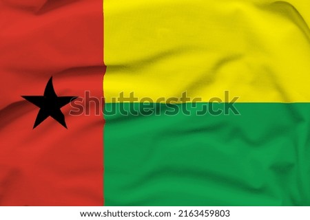 Guinea-Bissau national flag, folds and hard shadows on the canvas.