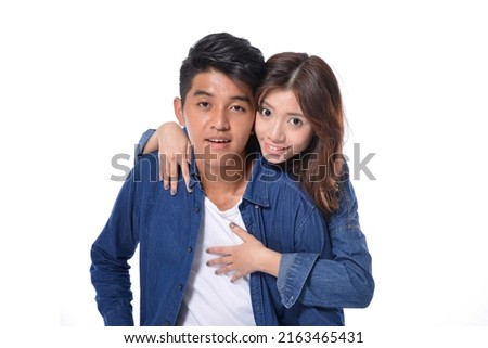 young couple standing together posing in studio