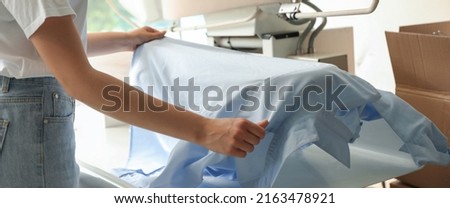 Closeup view of female worker using ironing press, banner design. Dry-cleaning service Royalty-Free Stock Photo #2163478921