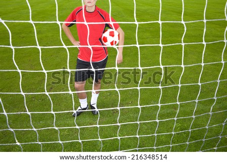 Soccer player standing at goal net