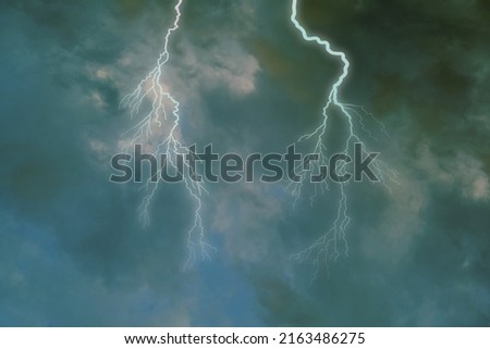 dramatic stormy sky with dark clouds, lightning flashes over the night sky. Concept on the theme of Severe Weather, natural disasters, hurricane, typhoon, tornado, storm, natural basis for designer Royalty-Free Stock Photo #2163486275