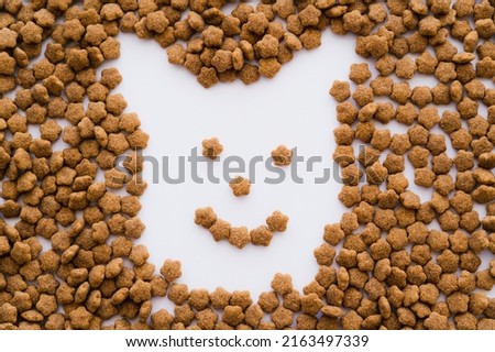 flat lay of dry pet food in shape of cartoon dog on white