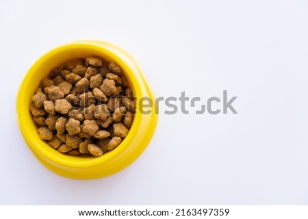 top view of yellow plastic bowl with pet food isolated on white
