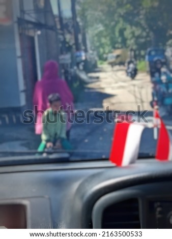 defocused abstract background of boy with mom on a bike shot from inside car