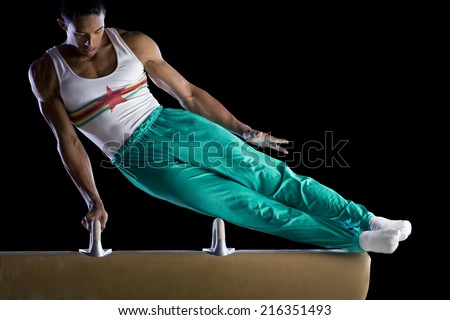 Male gymnast performing on pommel horse, low angle view