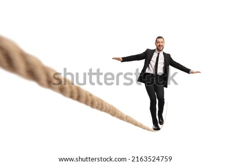 Businessman walking on a tightrope and smiling isolated on white background