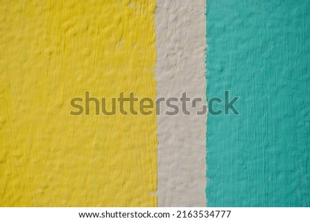 A yellow and blue wall painted with stripes and a triangle