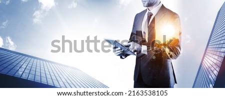 Holding tablet business. Businessman analyzing economic growth graph chart and data sales on double exposure. Digital marketing technology banner
