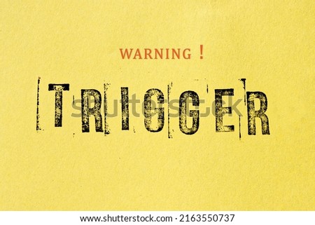 Trigger warning sign message on yellow background. Stamp letters mental triggering concept. Royalty-Free Stock Photo #2163550737