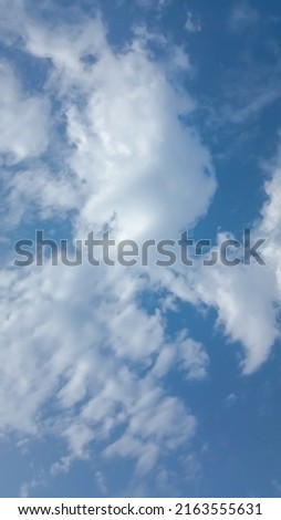 Beautiful white clouds on deep blue sky background. Elegant blue sky picture in daylight. Big soft white fluffy clouds in the blue sky background. Cumulus glowing clouds in sunny day. No focus