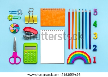 Frame from school and office supplies Paper clips, pens, calculator, sharpener, notepad, stapler isolated on blue background Flat lay Top view Back to school, education concept Mock up Copy space Royalty-Free Stock Photo #2163559693