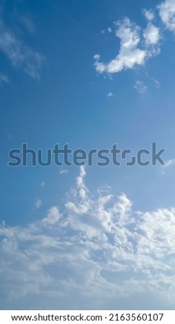 Beautiful white clouds on deep blue sky background. Elegant blue sky picture in daylight. Big soft white fluffy clouds in the blue sky background. Cumulus glowing clouds in sunny day. No focus