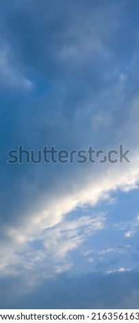 Beautiful black clouds on blue sky background. Elegant blue sky picture in daylight. Big glowing soft black fluffy rainy clouds in the blue sky background. Cumulus clouds texture background. No focus