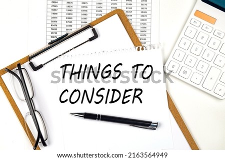 Text THINGS TO CONSIDER on white paper on clipboard with chart and calculator