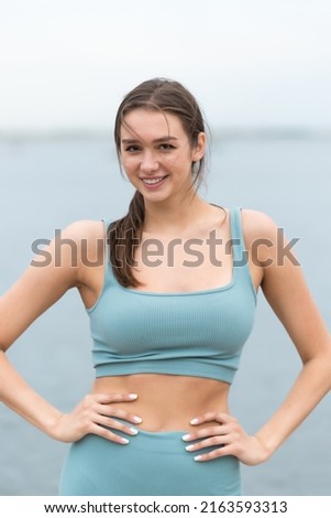 A healthy young athlete engaged in fitness. Looks at the camera. Dressed in sportswear